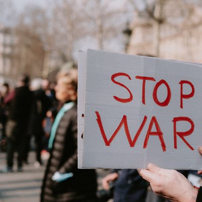 Demonstrierender mit einem Schild mit der Aufschrift "Stop War"