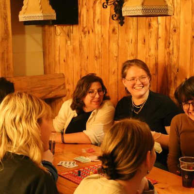 Aktivistinnen sitzen um einen Tisch und spielen Karten