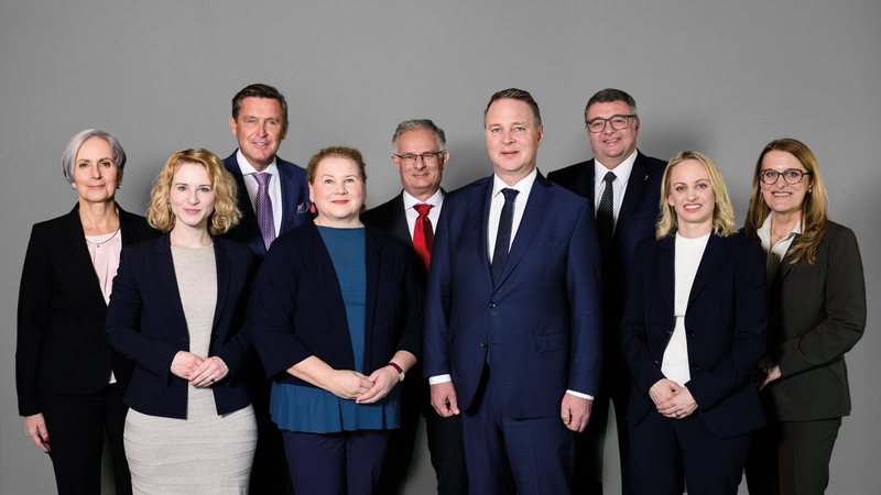 Abgebildet sind die Mitglieder der Bundesregierung aus dem Kreise der Sozialdemokratischen Partei Österreichs. 
Von links nach rechts: Anna Sporrer, Eva-Maria Holzleitner, Peter Hanke, Corinna Schumann, Markus Marterbauer, Andreas Babler, Jörg Leichtfried, Michaela Schmidt, Ulrike Königsberger-Ludwig